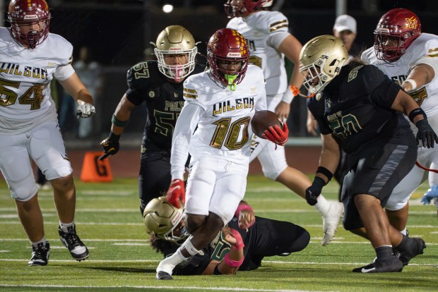 Wilson's Jemel Grigsby carries the ball and gains yards during a Moore League high school football rivalry game against Long Beach Poly at Cabrillo High School in Long Beach, California, Saturday, Oct. 10, 2026. (Photo by Mark Savage, Contributing Photographer)
