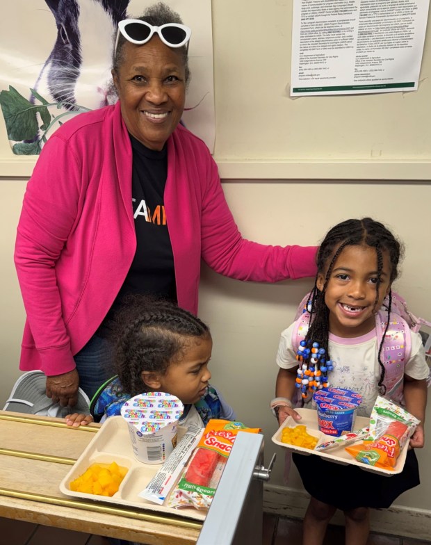 Patsy Stallings brought her great-grandchildren, kindergartener Micah Coste and first grader Mylene Coste, early to Sessions Elementary so they could eat breakfast before their classes. (Cyril A Reinicke)