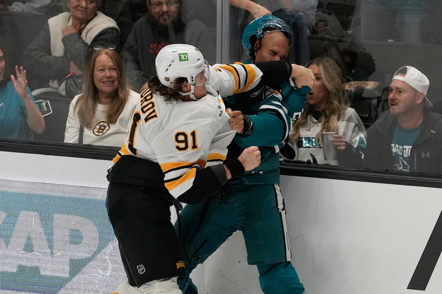 A Bruins fan in the front row (left) gleefully enjoys Nikita Zadorov (91) showing some knuckle-love to Sharks counterpart Darnell Nurse in the third period of Boston's win in San Jose last Tuesday night.