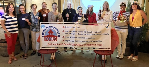Pamo Valley Winery owner Jennifer Lane, left, and former FORUS President Andrea Gibson, right, with the winners in last year's Halloween Eve Wine Bingo. (Maureen Robertson)
