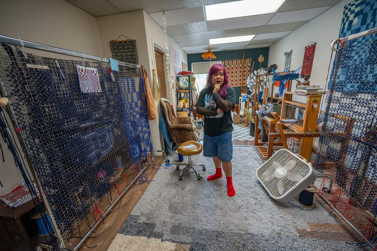 Artist Jamie Pesquiza Cardenas stands last month near one of the four panels of a mural she is creating in her Sacramento studio. It’s part of the “Threads of Belonging” project, a response to people in Sacramento who aren’t being represented, she said.