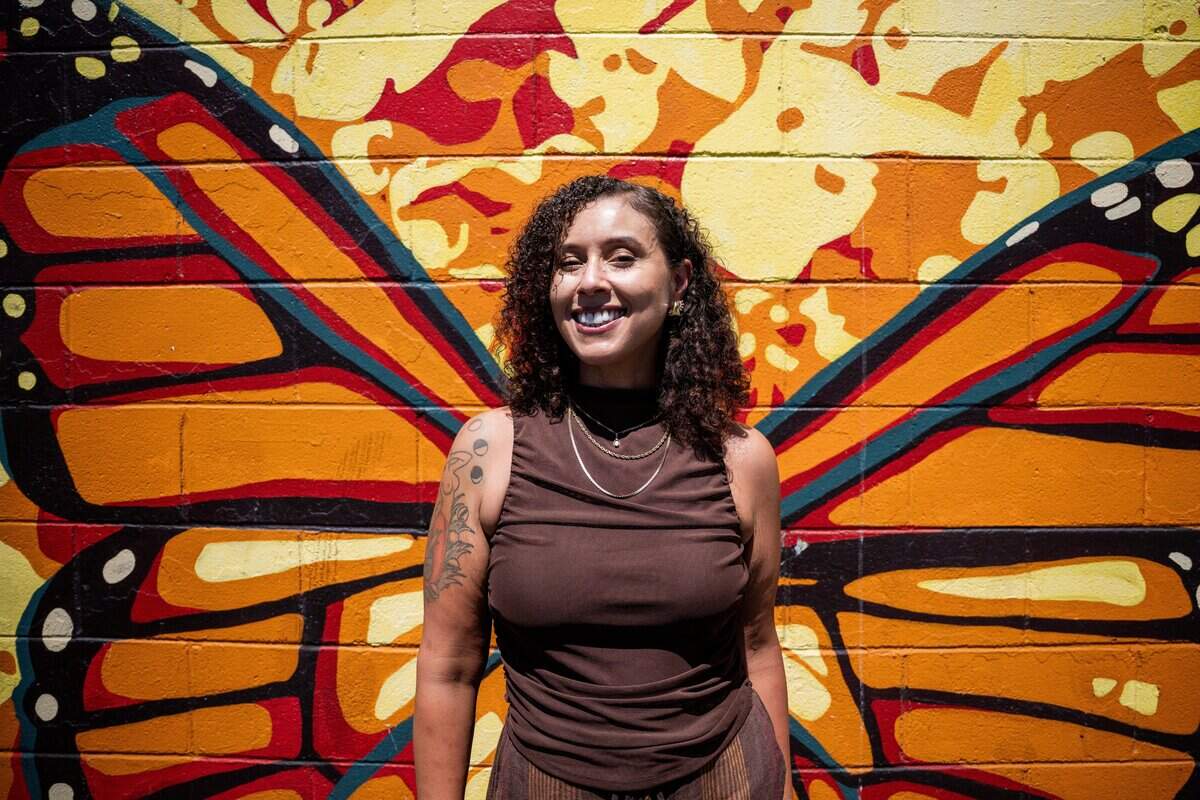 Artist Beth Consetta Rubel poses for a picture last month in front of her mural “Rhythm and Victory,” which celebrates the diverse Northgate community, at Taco Plaza in Sacramento.