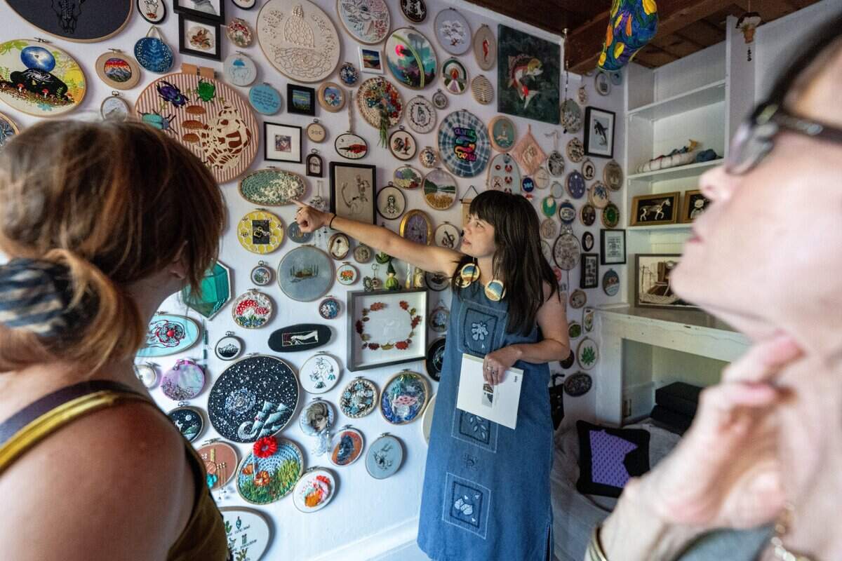 Corinna Fish, center, displays her embroidery collection to visitors at her Sacramento home on Sept. 29.