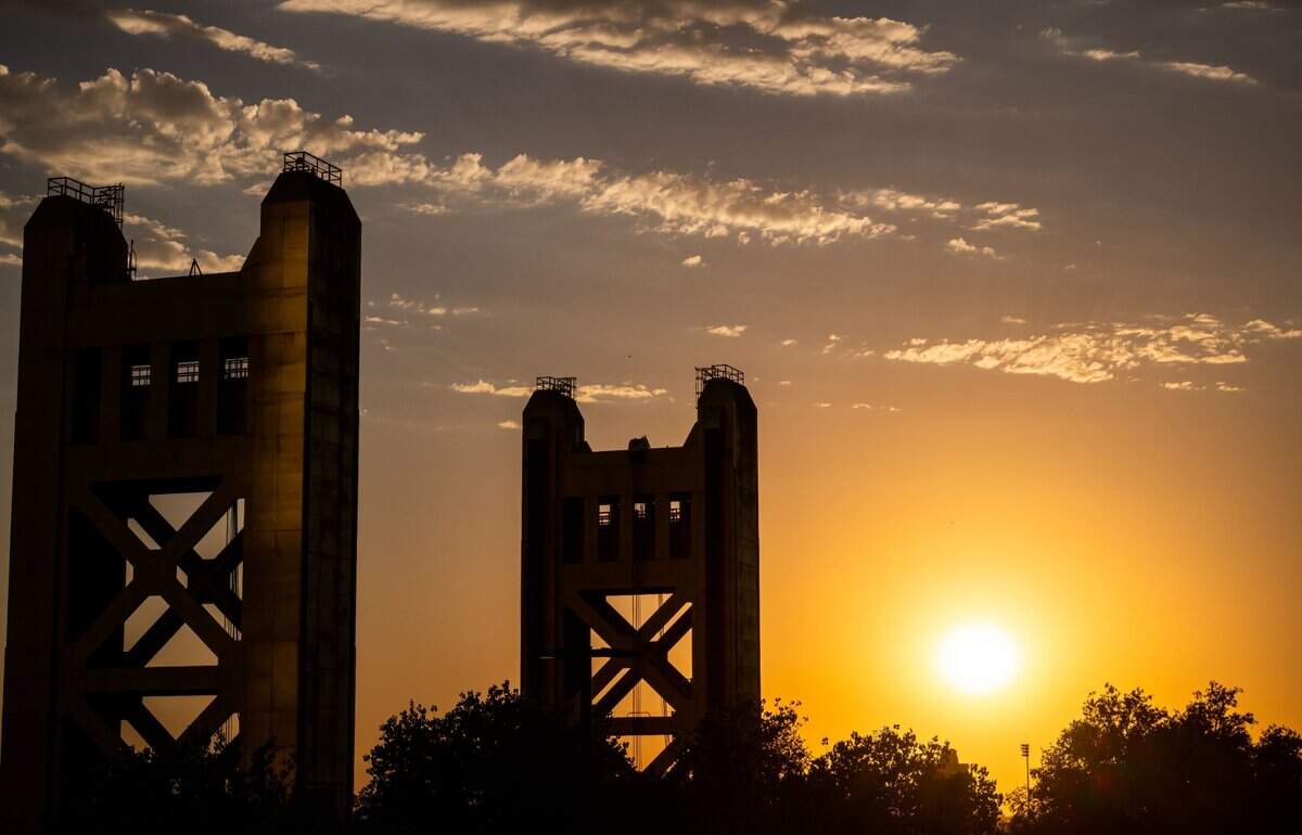 The sun sinks lower in the sky past the Tower Bridge on the day downtown Sacramento reaches an all-time high temperature of 116 degrees on Sept. 6, 2022, surpassing the record of 114 set on July 17, 1925, according to the National Weather Service.