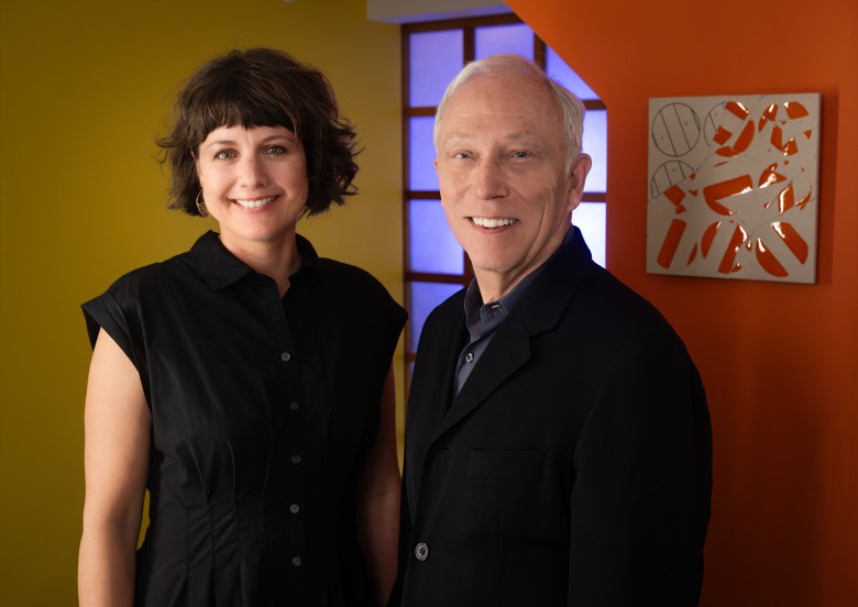 A woman and a man standing side by side smiling.