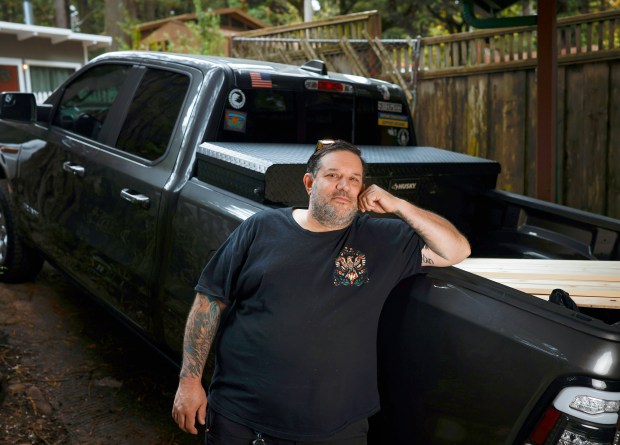 David Collins, 53, stands by his work truck at a house he is working on in Woodside, Calif., on Thursday, Sept. 17, 2026. David, an electrician, is a 5th-generation Californian who is considering moving because of affordability. (Shae Hammond/Bay Area News Group)