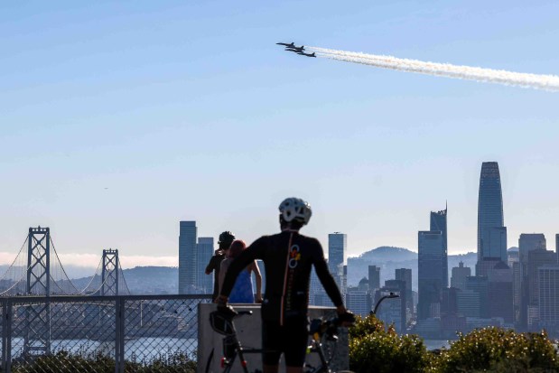Spectators watch the U.S. Navy Blue Angels fly over the San Francisco Bay during a practice flight for San Francisco Fleet Week, as seen from Treasure Island in San Francisco, Calif., on Thursday, Oct. 8, 2026. (Ray Chavez/Bay Area News Group)
