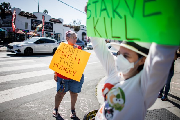 Unhoused Response Group founder Shaunn Cartwright, center, and other supporters of Lighthouse Food Rescue & Distribution hold signs outside the food distribution site in San Jose, Calif., on Oct. 12, 2026. (Dai Sugano/Bay Area News Group)