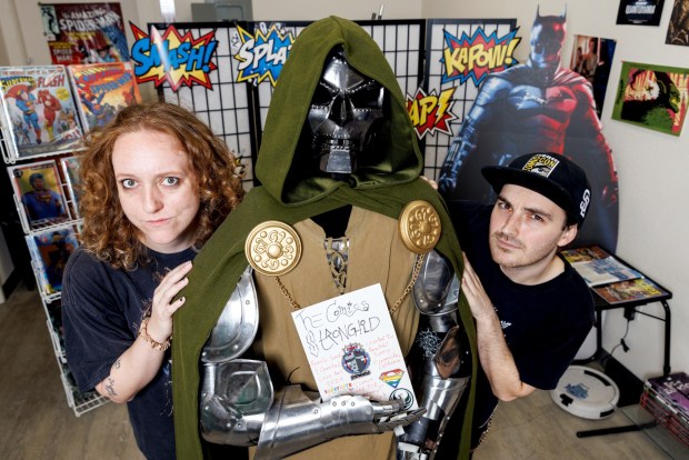 Co-owner Kristin Wilson, who runs the store alongside her partner Gavin Wilson and father-in-law, pose inside The Comics Stronghold in Oceanside on Sept. 22. 2026. After becoming unemployed, Wilson and her partner half-jokingly brought up the idea of opening a store. Her father-in-law was serious about it. He presented them with documents to officially open a store and they have now been running it for three years. Kristin Wilson's current favorite comic is "Supernatural" from her favorite television show and Gavin Wilson's favorite comic is Absolute Martian Manhunter.