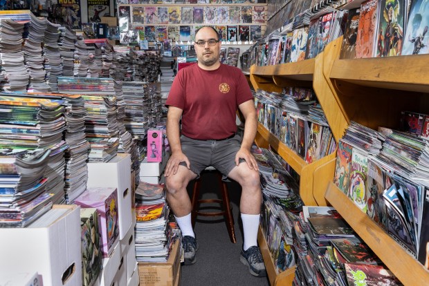 Michael Cholak poses among stacks of comics at his store Yesteryear in Clairemont on August 18, 2026. Cholak, 53, had trouble reading as a child, so at his grandmother's discretion, his father bought him a handful of "Star Wars" comics to help improve his reading ability. Originally a wholesale comic book dealer, Cholak decided to open a store 14 years ago. Cholak's favorite comic series is "Dark Knight Returns"