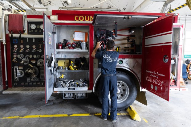 Jake Jarvis, CalFire fire apparatus engineer, checks equipment in the apparatus bay at the San Diego County Fire Station 45 on Wednesday, Sept. 9, 2026, in Descanso. (Luke Johnson / The San Diego Union-Tribune)