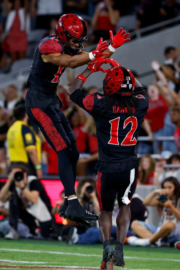 Jacob Bostick #17 and Jaylon Hawkins #12 of San Diego State celebrate after a touchdown against Fresno State during their game at Snapdragon Stadium on Saturday, Oct. 17, 2026 in San Diego, California. (Meg McLaughlin / The San Diego Union-Tribune)