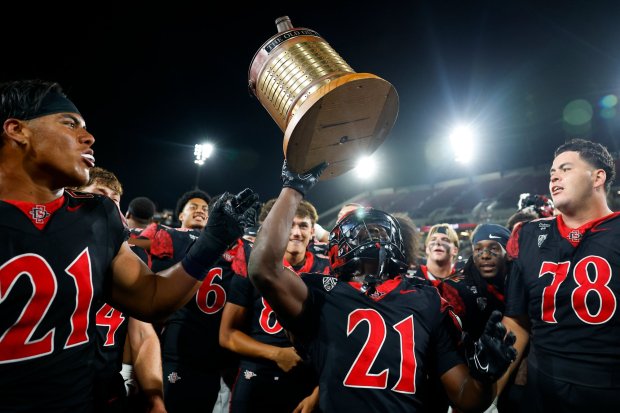 Javion Kinnard of San Diego State holds The Old Oil Can trophy after the Aztecs' defeated Fresno State during their game at Snapdragon Stadium on Saturday, Oct. 17, 2026 in San Diego, California. (Meg McLaughlin / The San Diego Union-Tribune)