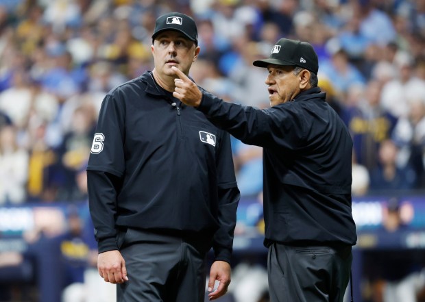 Umpires discuss a call after Ty France hit a pop fly that hit the roof in the ninth inning against the Milwaukee Brewers during Game One of the National League Division Series at American Family Field on October 3, 2026 in Milwaukee, WI. (K.C. Alfred / The San Diego Union-Tribune)