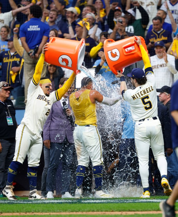 Jackson Chourio of the Milwaukee Brewers has Gatorade poured on him by William Contreras (24) and Garrett Mitchell (5) after his game-winning two-run single in Sunday's National League Division Series win over the Padres. (K.C. Alfred / The San Diego Union-Tribune)
