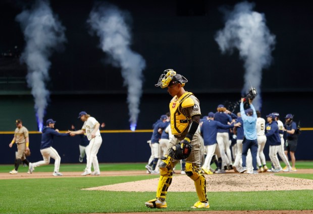 Padres catcher Freddy Fermin walks off the field as the Milwaukee Brewers celebrate a walk off single by Jackson Chourio in the ninth inning of Sunday's Game 2 of the National League Championship Series. (K.C. Alfred / The San Diego Union-Tribune)