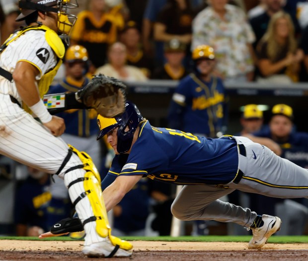 San Diego, CA - October 6: Cooper Pratt #12 of the Milwaukee Brewers scores past Ethan Salas #8 in the fifth inning during game three of the National League Division Series at Petco Park on October 6, 2026 in San Diego, CA. (K.C. Alfred / The San Diego Union-Tribune)