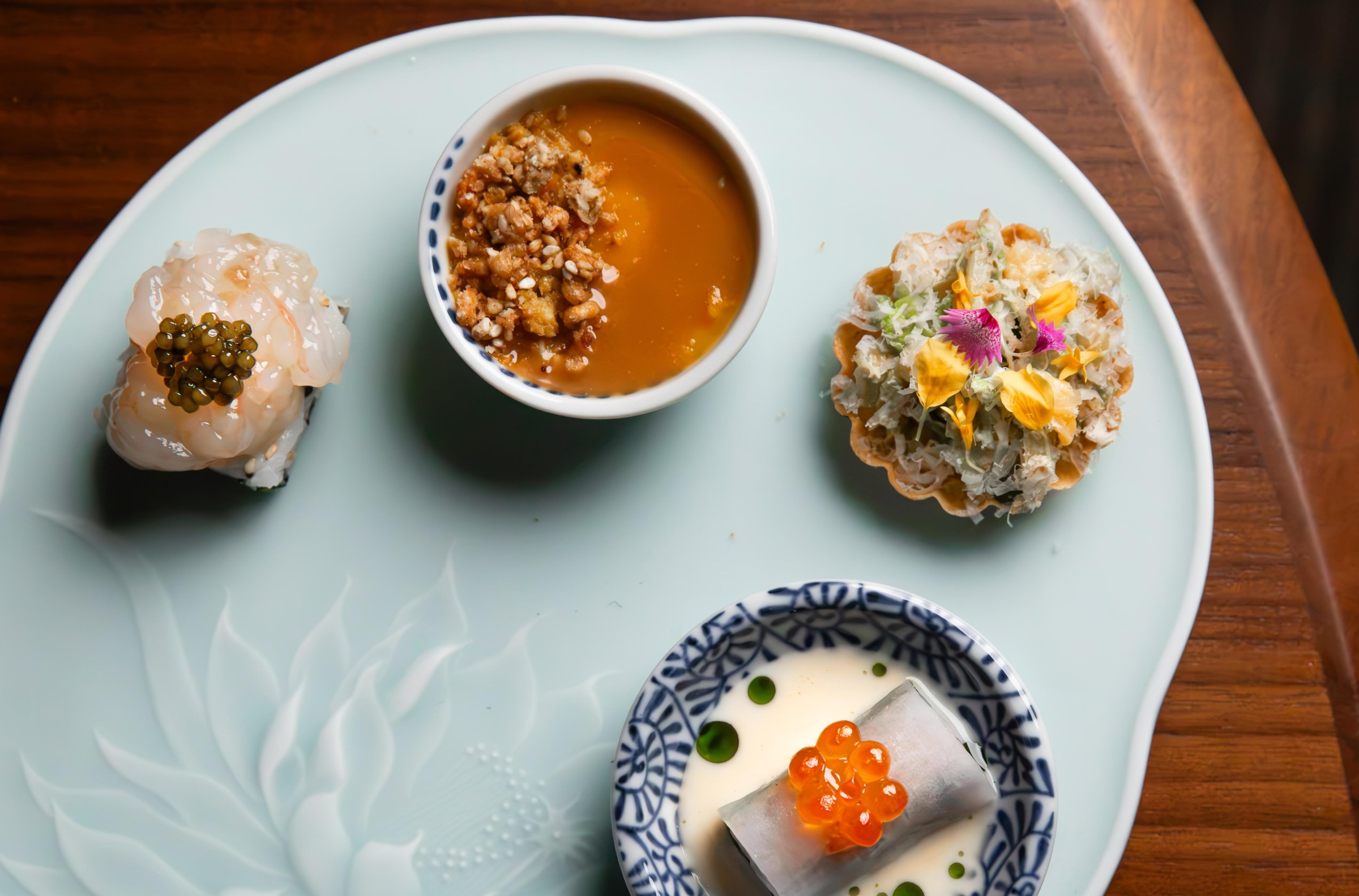 Four different bites on a singular plate at Shinka in San Francisco.