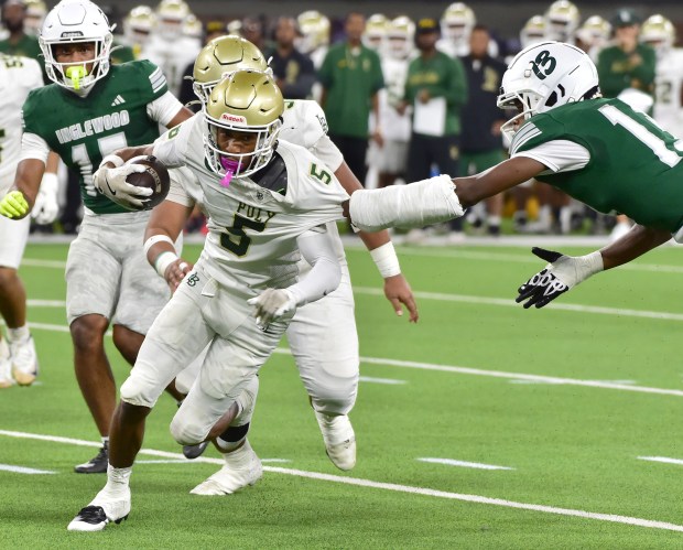Long Beach Poly receiver Zion Anderson gets grabbed by Inglewood defender Derion Long during football game Friday September 18, 2026 at SoFi Stadium (Photo by Robert Casillas, Contributing Photographer)