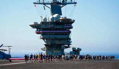 Crew members take part in a traditional 5K run, called the Ship to Shore 5K Scramble, doing several laps on the flight deck of the US Abraham Lincoln's on Oct. 7, 2026, on their return to its home port at Naval Air Station North Island in San Diego, Calif.