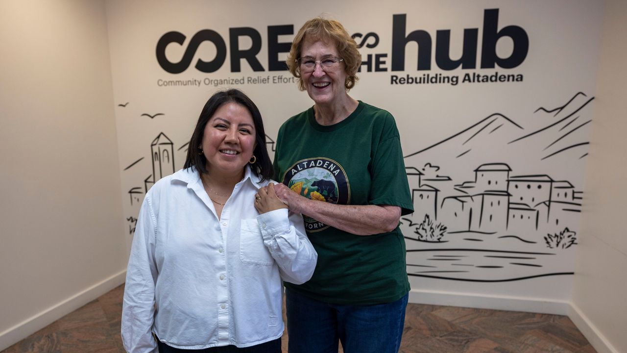 Veda Ashby Romero, left, a disaster case manager for CORE, poses for a portrait with Mary Landau, a fire survivor, at the CORE resource center on Thursday, Oct. 15, 2026, in Altadena, Calif. (AP Photo/Jill Connelly)
