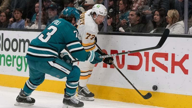 Boston Bruins defenseman Charlie McAvoy, right, reaches for the puck against San Jose Sharks center Tyler Toffoli during the first period of an NHL hockey game, Tuesday, Oct. 13, 2026, San Jose, Calif. (AP Photo/Jeff Chiu)