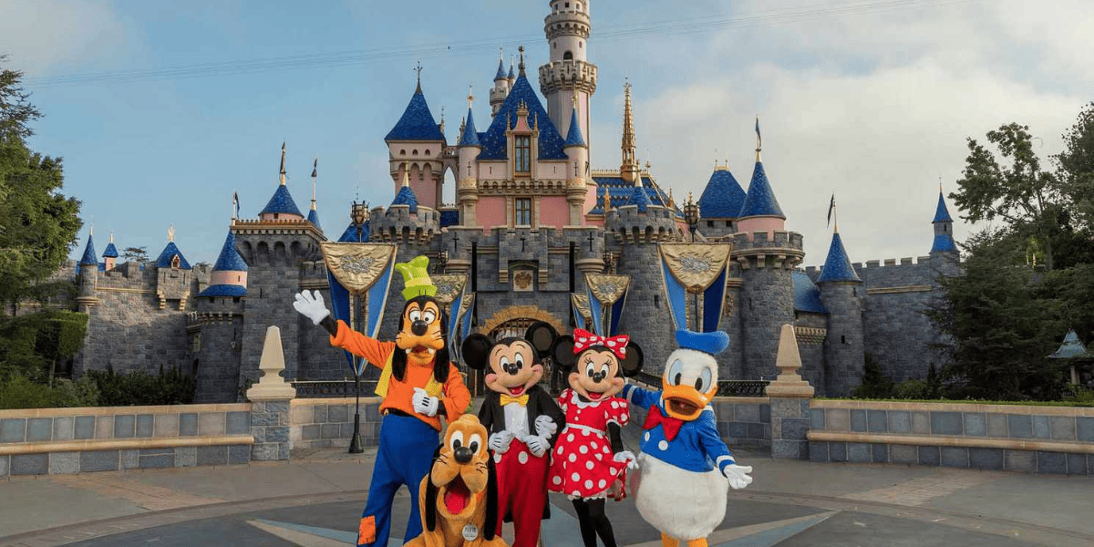 Disney Characters posing in front of Sleeping Beauty Castle as Disney news makes history.