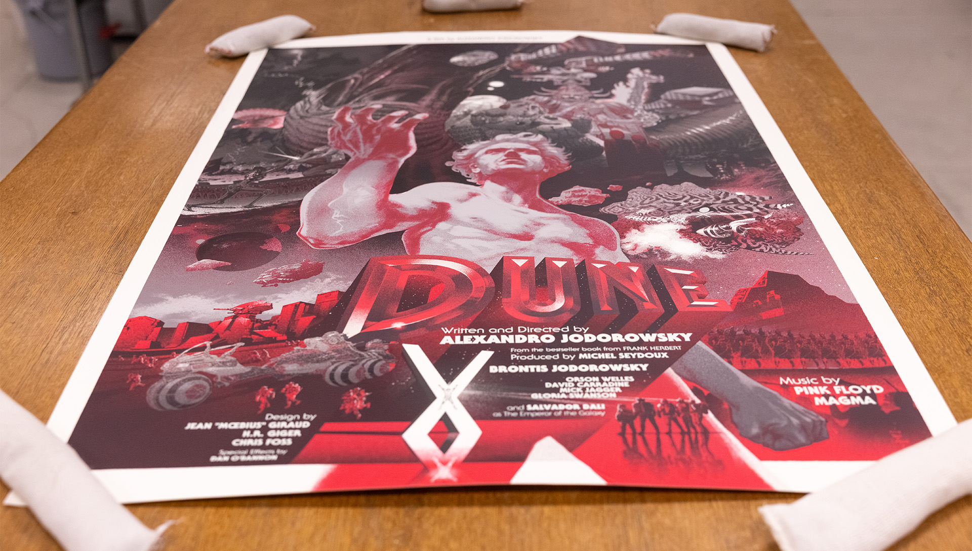 Poster, mostly in red shades and white, for the movie Dune