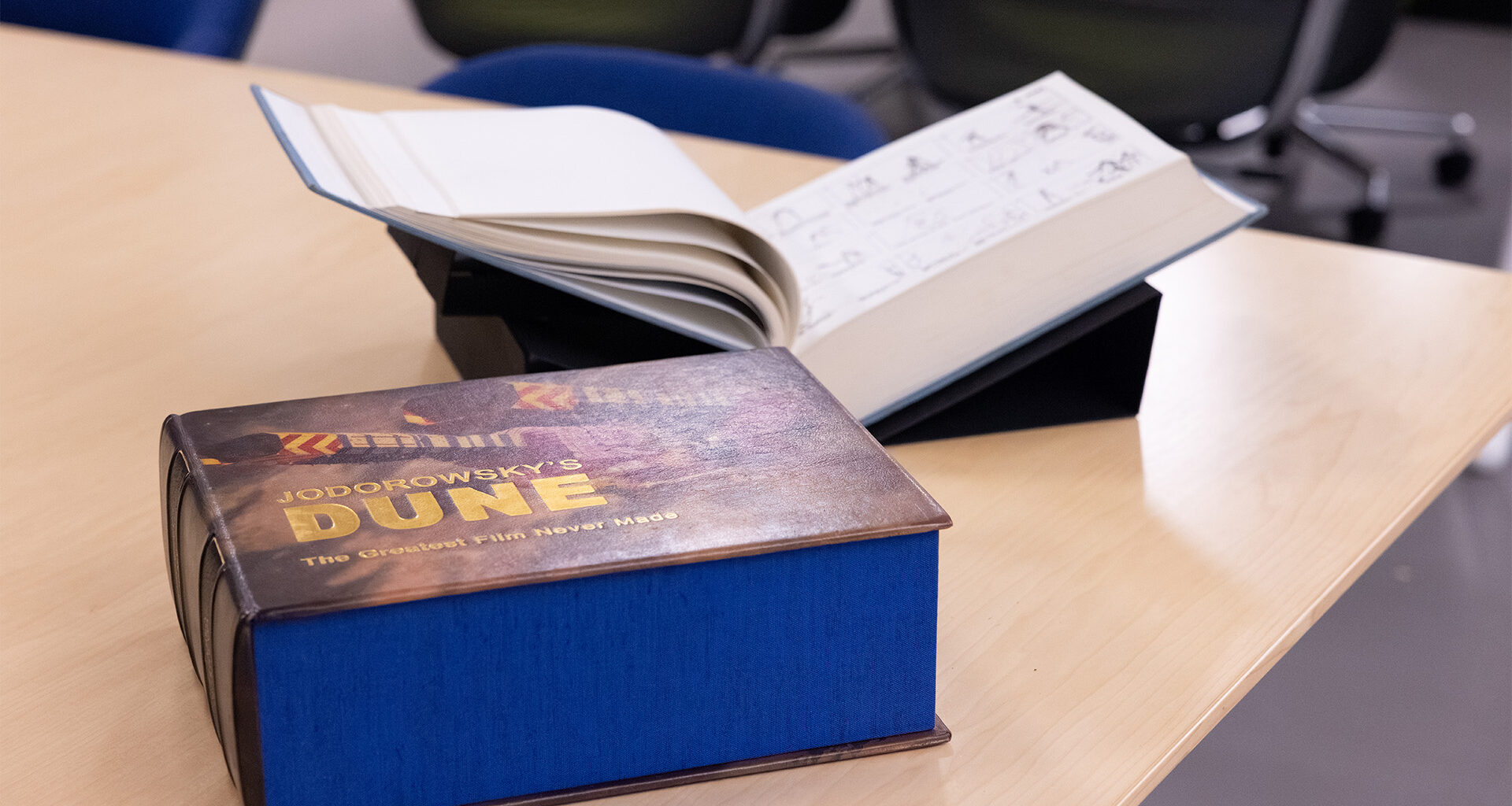 A large rectangular book sl;ipcase entitled Jodorowsky's Dune The Greatest Film Never Made with the book itself blurred in background.