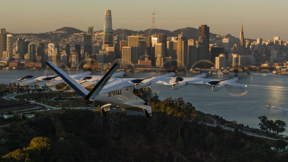 Archer’s Midnight air taxi in flight at golden hour with the San Francisco skyline behind