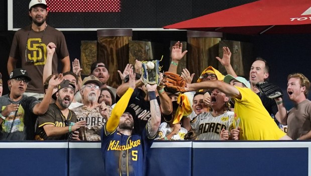 Brewers center fielder Garrett Mitchell reaches above the outfield wall to catch a ball hit by the Padres' Manny Machado during the eighth inning in Game 4 of their National League Division Series on Wednesday night in San Diego. The Brewers held on for a 3-1 win to advance to the NL Championship Series against the Dodgers. (AP Photo/Gregory Bull)