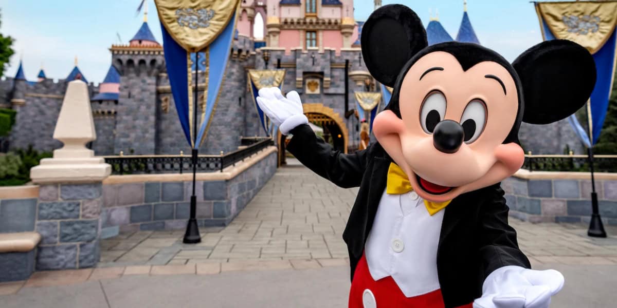 Mickey Mouse stands in front of Sleeping Beauty Castle at Disneyland Park, Disneyland Resort