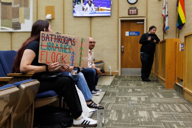 San Diego, California - A member of the public holds up a sign during a budget committee meeting that discussed the use of automatic licensce plate readers at City Hall on Wednesday, Oct. 21, 2026. (Kristian Carreon / The San Diego Union-Tribune)