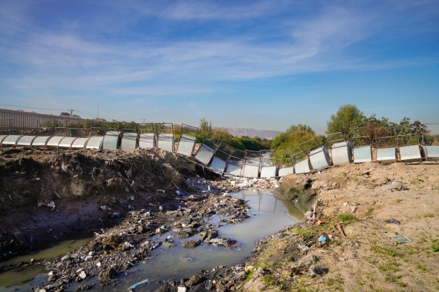 Officials showed off a newly constructed trash boom that stretches across a galvanized steel cable with 150 rigging attachments to catch floating debris in the Tijuana River Valley before it reaches the thick vegetation and the ocean. (Nelvin C. Cepeda / The San Diego Union-Tribune)