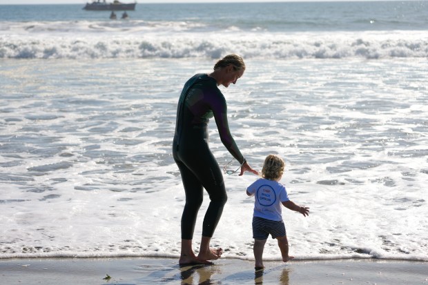 Catherine Breed, 33 from Marin County, enjoys a moment with her nephew, Leon Breed, 2. Earlier Breed reached the beach at Coronado on Monday, Oct. 19, 2026, in Coronado, CA. Breed began her swim from Brookings, Oregon, to the Mexico border, taking 111 days from the start until Monday, October 19th, and completing nearly 900 miles. (Nelvin C. Cepeda / The San Diego Union-Tribune)