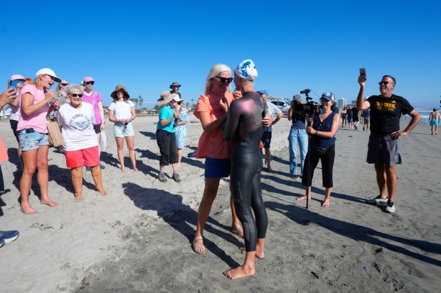 Catherine Breed, 33 from Marin County, is greeted by family and friends after completing her California coast swim. Earlier Breed reached the beach at Coronado on Monday, Oct. 19, 2026, in Coronado, CA. Breed began her swim from Brookings, Oregon, to the Mexico border, taking 111 days from the start until Monday, October 19th, and completing nearly 900 miles. (Nelvin C. Cepeda / The San Diego Union-Tribune)