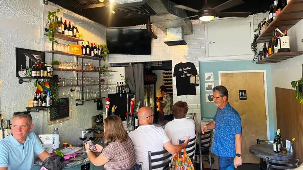 five bar patrons sit inside Bar Chinchilla, the smallest bar in st pete with a great happy hour