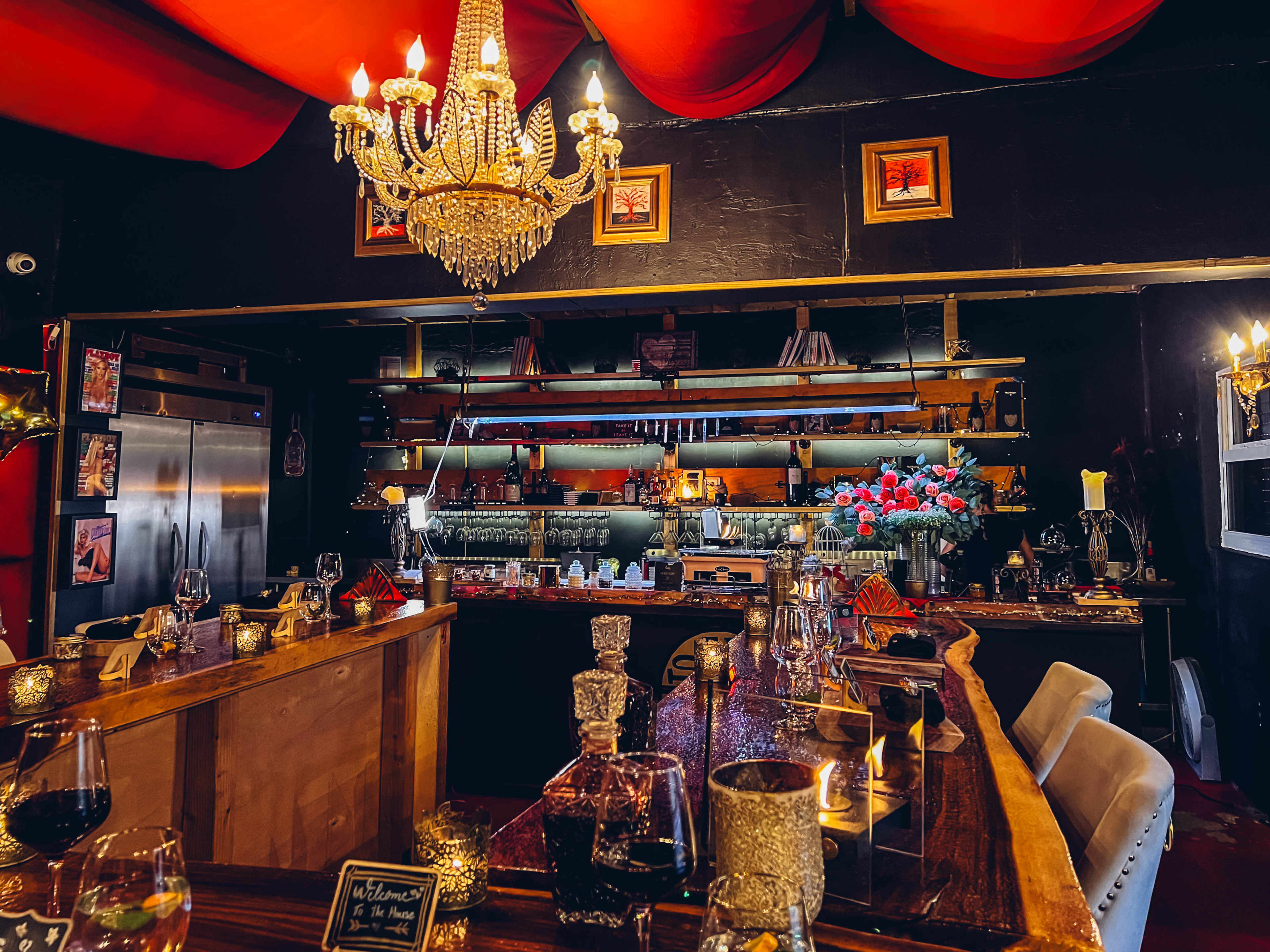 Restaurant interior with ceiling drapes, chandelier, and u-shaped wooden table