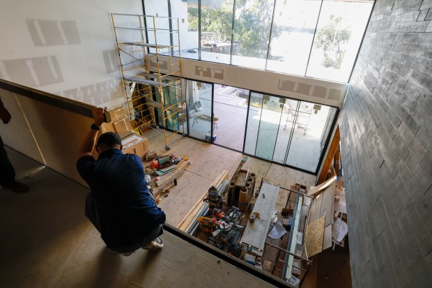 A worker measures for the placement of the glass balcony...