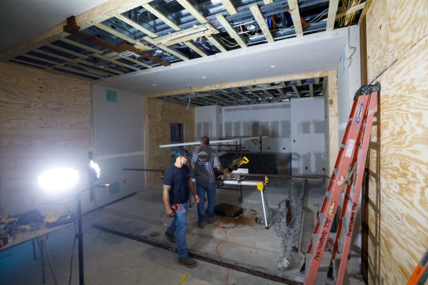 Workers measure the wood paneling to be installed in the...