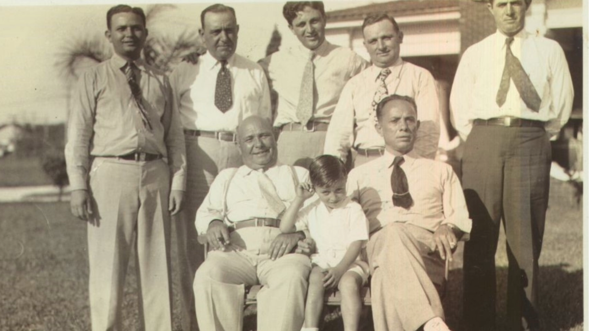 Historic photo of Tampa mob figures from the early 20th century posing outdoors in suits, representing the city’s organized crime network during the bolita gambling era.