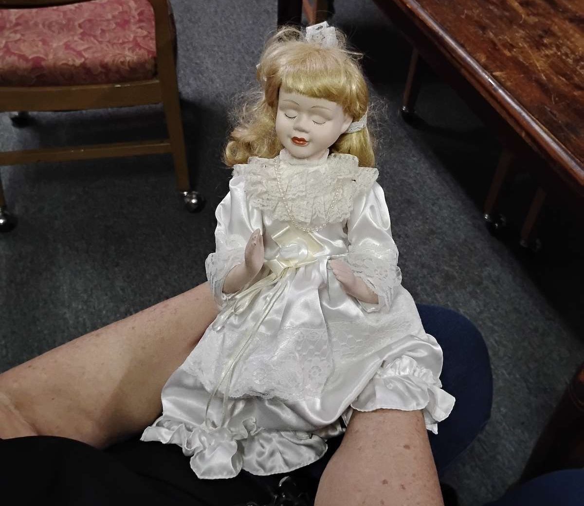 a person holding an old porcelain doll.