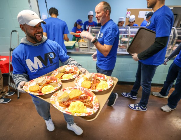 Volunteer David Painter is ready to serve with a tray of meals at the Orlando Magic 33rd Annual Thanksgiving Breakfast in partnership with the Coalition for the Homeless of Central Florida at their downtown campus on Thursday morning. (Joe Burbank/Orlando Sentinel)
