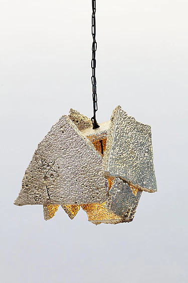 Modern hanging pendant light with a geometric, textured design in beige, suspended from a black chain against a neutral background