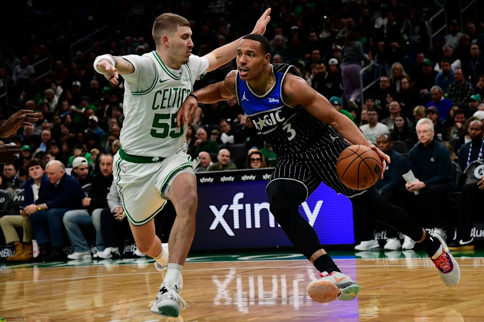 Nov 23, 2025; Boston, Massachusetts, USA; Orlando Magic guard Desmond Bane (3) controls the ball while Boston Celtics guard Baylor Scheierman (55) defends during the first half at TD Garden. Mandatory Credit: Bob DeChiara-Imagn Images