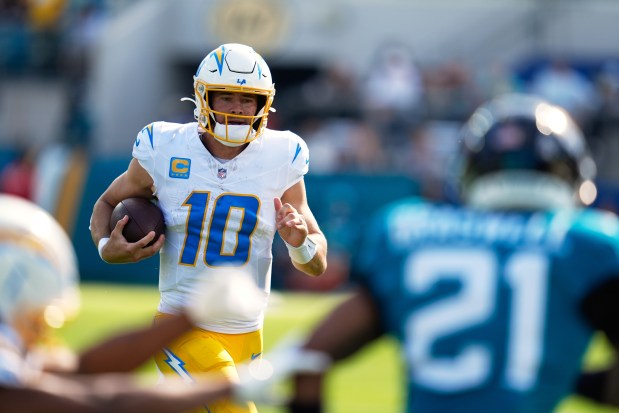 Chargers quarterback Justin Herbert (10) runs during the first half...