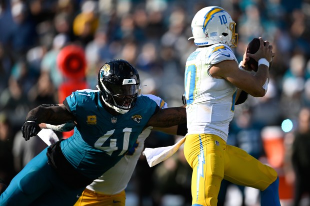 Chargers quarterback Justin Herbert (10) is pressured by Jacksonville Jaguars...