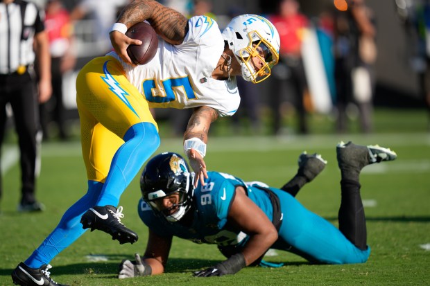 Chargers quarterback Trey Lance (5) escapes Jacksonville Jaguars defensive end...
