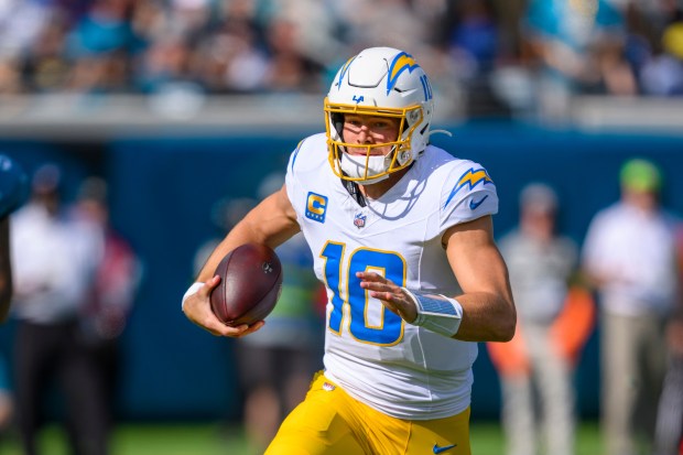 Chargers quarterback Justin Herbert (10) runs with the ball during...