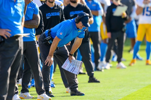 Chargers head coach Jim Harbaugh looks down on the sidelines...